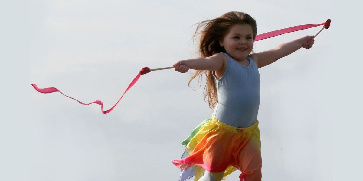 A little girl is going solo and is flying ribbons